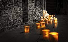 a collection of burning candles in front of a temple altar