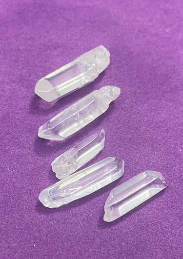 different sized white crystals on a purple background