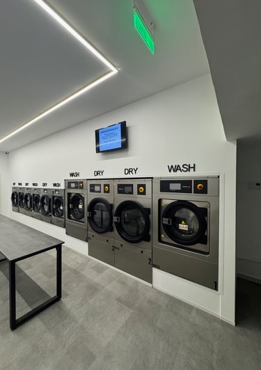a row of washing machines in a laundry room