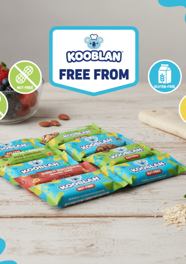 An assortment of Kooblan snack bars arranged on a wooden table featuring clear Nut-Free, Gluten-Free