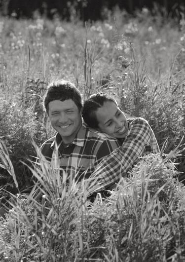 a man and a woman are sitting in the grass