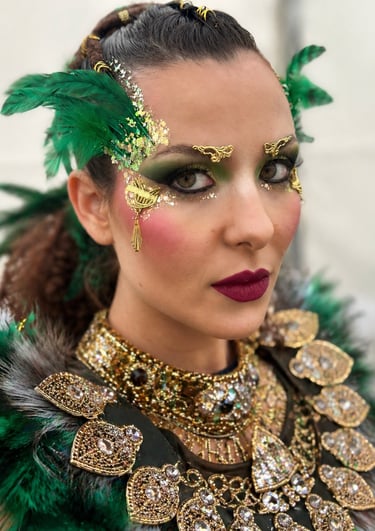 Woman in green carnival costume with gold glitter makeup and jeweled accessories.