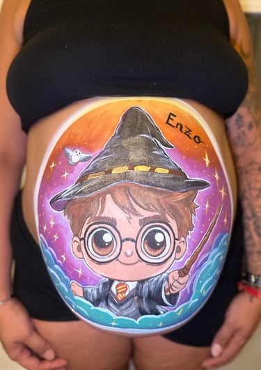 Harry Potter belly painting on a pregnant woman featuring a cartoon wizard and Hedwig the owl.