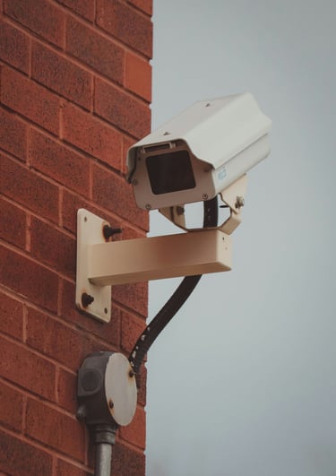a camera mounted to a brick wall near a brick wall