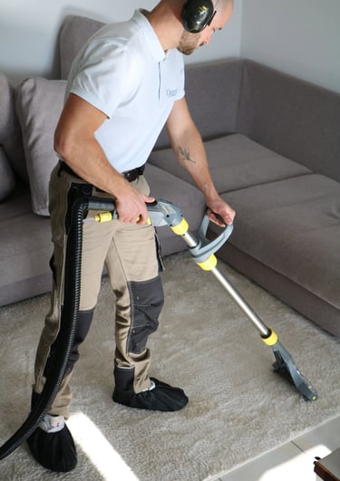 a man in a white shirt is using a vacuum cleaner