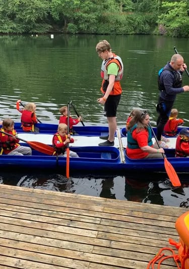 Beaver Scouts paddling a bell boat at the marina