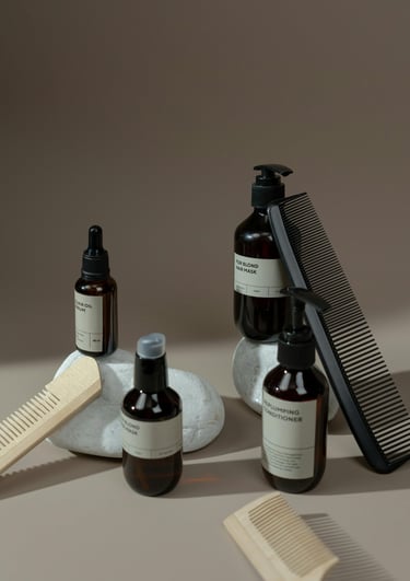 Productos capilares profesionales y peines sobre fondo de fotografía en tonos café y beige.