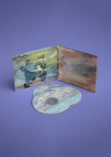 Interior del digipack Ilusiones/Visiones y galleta de CD sobre fondo púrpura