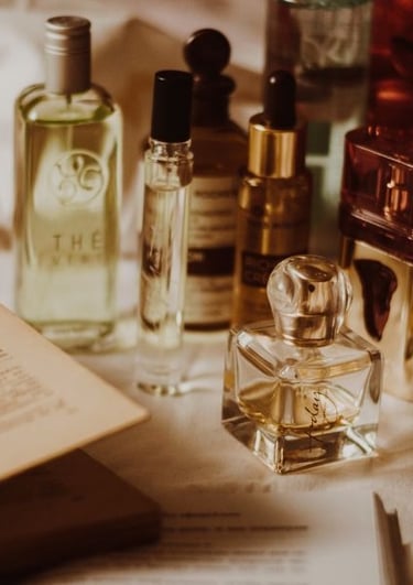 Colección de perfumes en botellas de vidrio sobre tocador