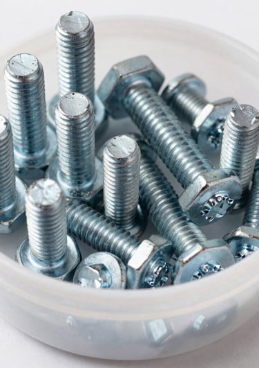 Assorted nuts and washers in a small container ready for use.