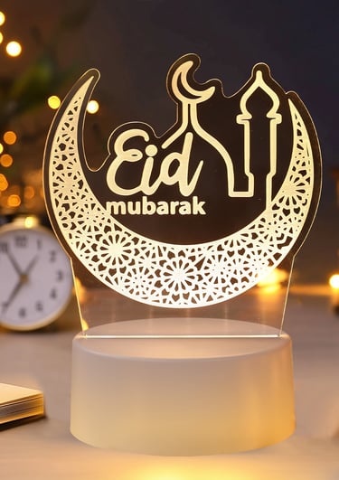 an LED lit desk top ornament with eid mubarak engraved on a crescent moon design  