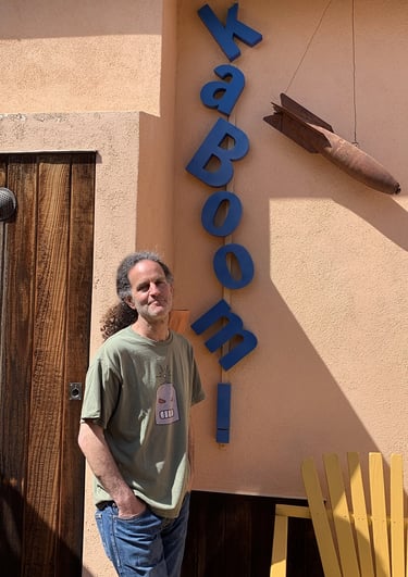 Artist Tal Avitzur next to KABOOM! sign.