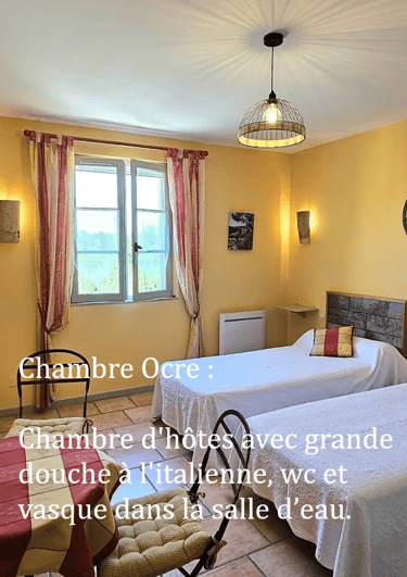 chambre Ocre de "la ramade" avec 2 lits séparés, une table et miroir rond, mur ton jaune ocre.