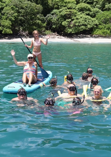 Family enjoying snorkeling and paddle boards in turquoise waters during catamaran tour Papagayo