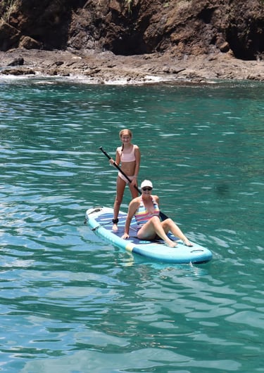 Couple stand-up paddleboarding in calm waters of Papagayo Gulf, Costa Rica