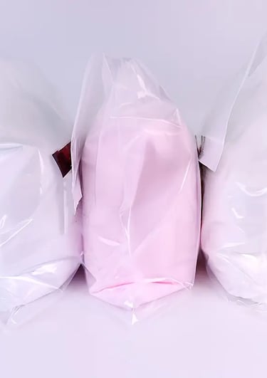 three bags of white and pink colored pillows