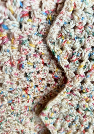 a close up of a crochet blanket with multicolored yarn