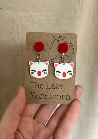 a card display of two Moogle acrylic earrings