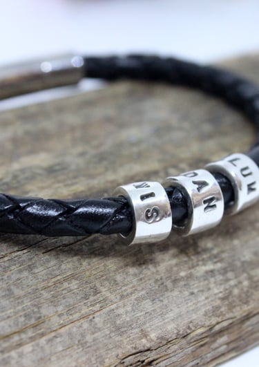 A silver name bead for each family member on a gents leather bracelet