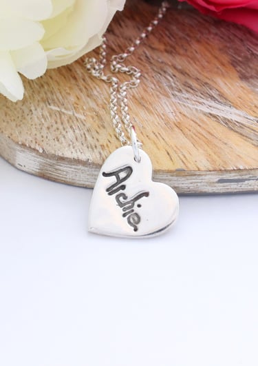 Your childs name, written by them, pressed onto a silver heart pendant