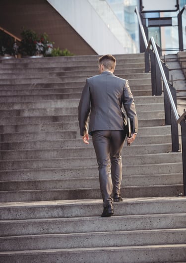 a man in a suit walking up stairs