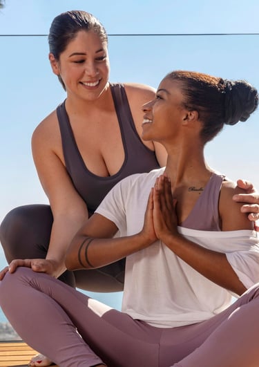 a woman in a yoga outfit is sitting on a wooden deck