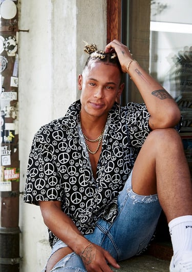 a man sitting on a ledge with a peace sign