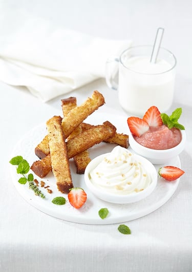 a plate with a bowl of strawberries and a glass of milk