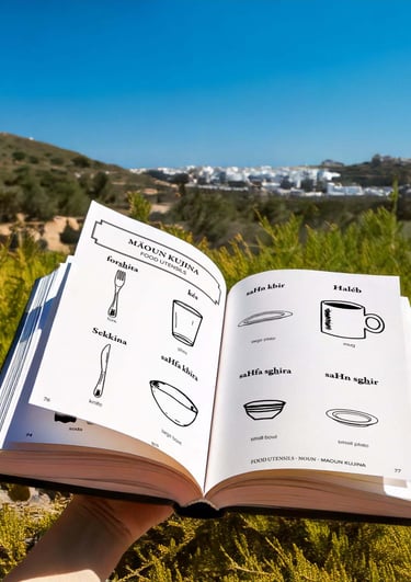 Person holding a Tunisian dictionary with images of objects and the Tounsi word associated.