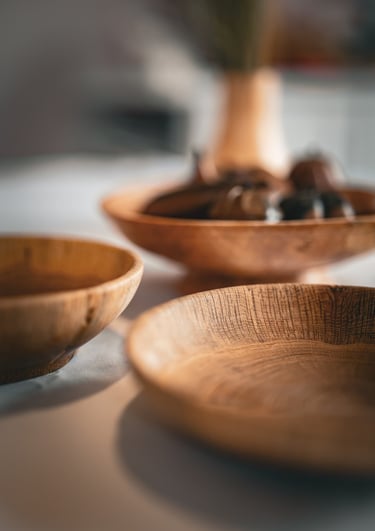 Composition artistique mettant en avant plusieurs bols et plats en bois faits main, posés sur une ta
