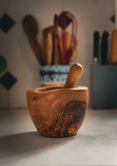 Mortier en bois massif artisanal accompagné de son pilon, posé sur un plan de travail dans une cuisi