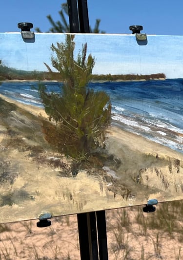 An original open-air plein air oil painting of the Lake Superior shoreline resting on a wooden field