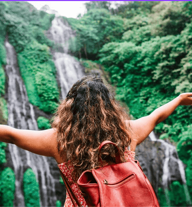 Sophro-balade :Femme ressentant l'énergie d'une cascade en forêt, moment de sérénité et reconnexion