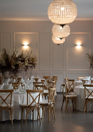 wedding table with white tablecloth and chairs and a chandelier