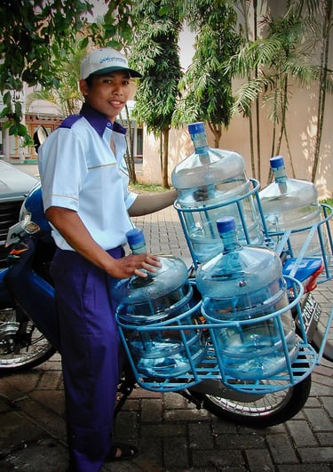 Yamin delivering bottled water by motorbike in Indonesia for Watermill