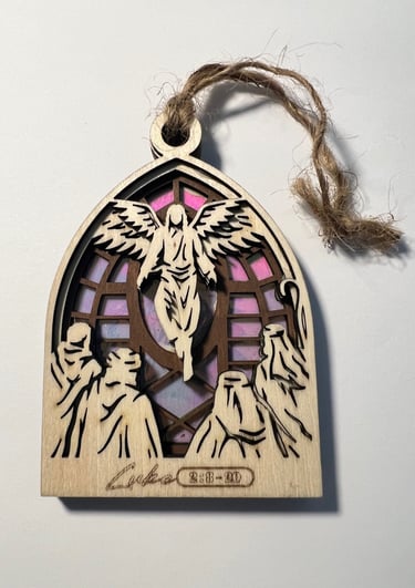Wooden langing ornament with angel and figures over a stained glass style background