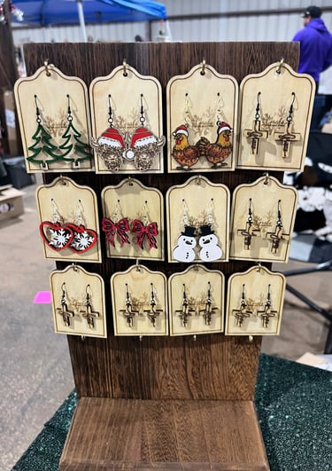 Wooden display fo handmade earrings with holiday and nature designs.