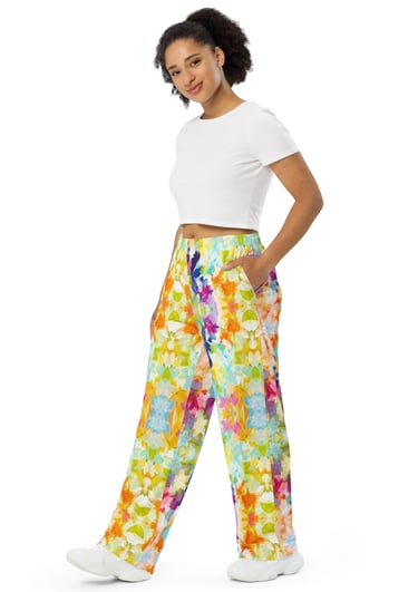 a woman in a white crop top and colorful floral pants