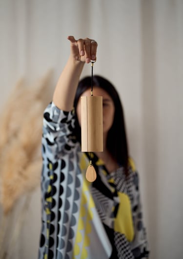 a woman holding a wooden wind chime
