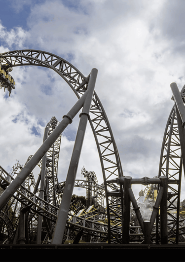A Roller coaster in the shape of eyes and a smile with a cart on a loop to the left  