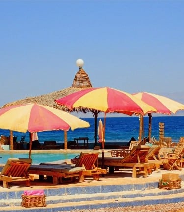 Bedouin star pool with umbrellas in front of the sea
