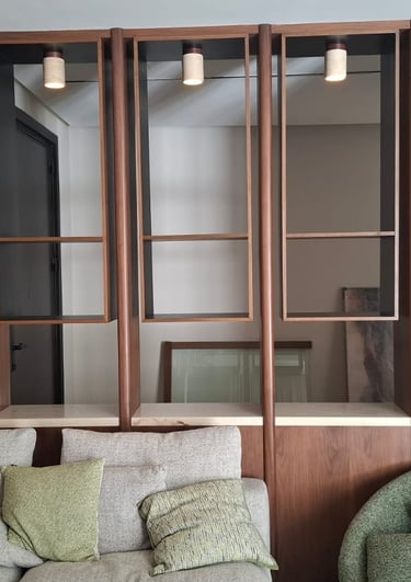 Modern living room with a custom wood wall unit, built-in shelving, and a grey sectional sofa.