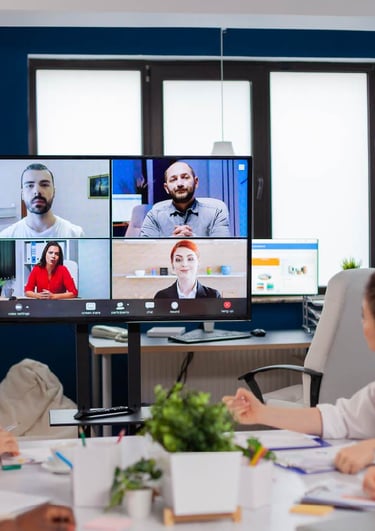 Hybrid meeting setup with participants on video call and in-person around a conference table – Sonus AV rental Dubai