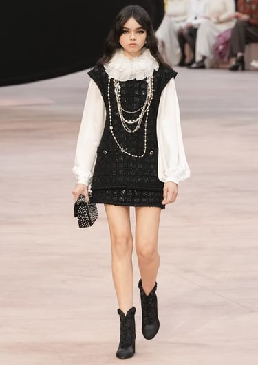 Black and white tweed mini dress with pearl necklaces at Chanel FW25/26.