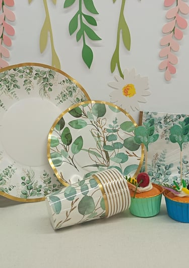 Floral eucalyptus paper plates and party supplies set with matching cups and napkins for a nature-themed event.