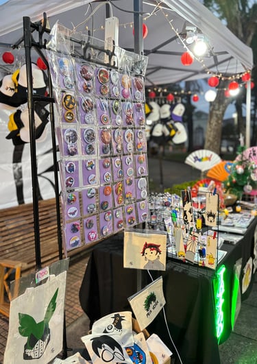 Stand de anime con pins, marcapáginas y tote bags
