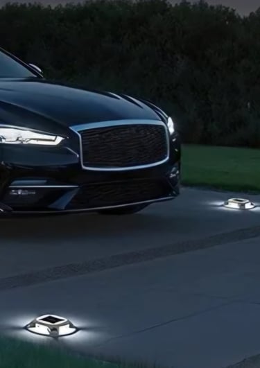 A black luxury sedan parked on a driveway illuminated by solar powered LED deck and dock lights.