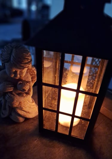 glowing candle lantern on porch with angel.