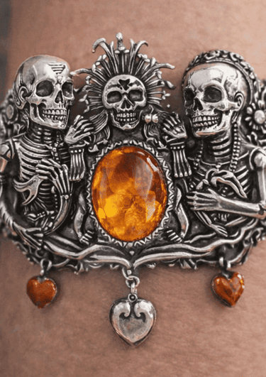 Brazalete en plata Mictlan ornamentada con calaveras y una gran piedra de ámbar en el centro.