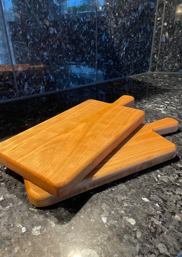 Zwei Servierbretter aus Kirschholz auf einer Küchenplatte